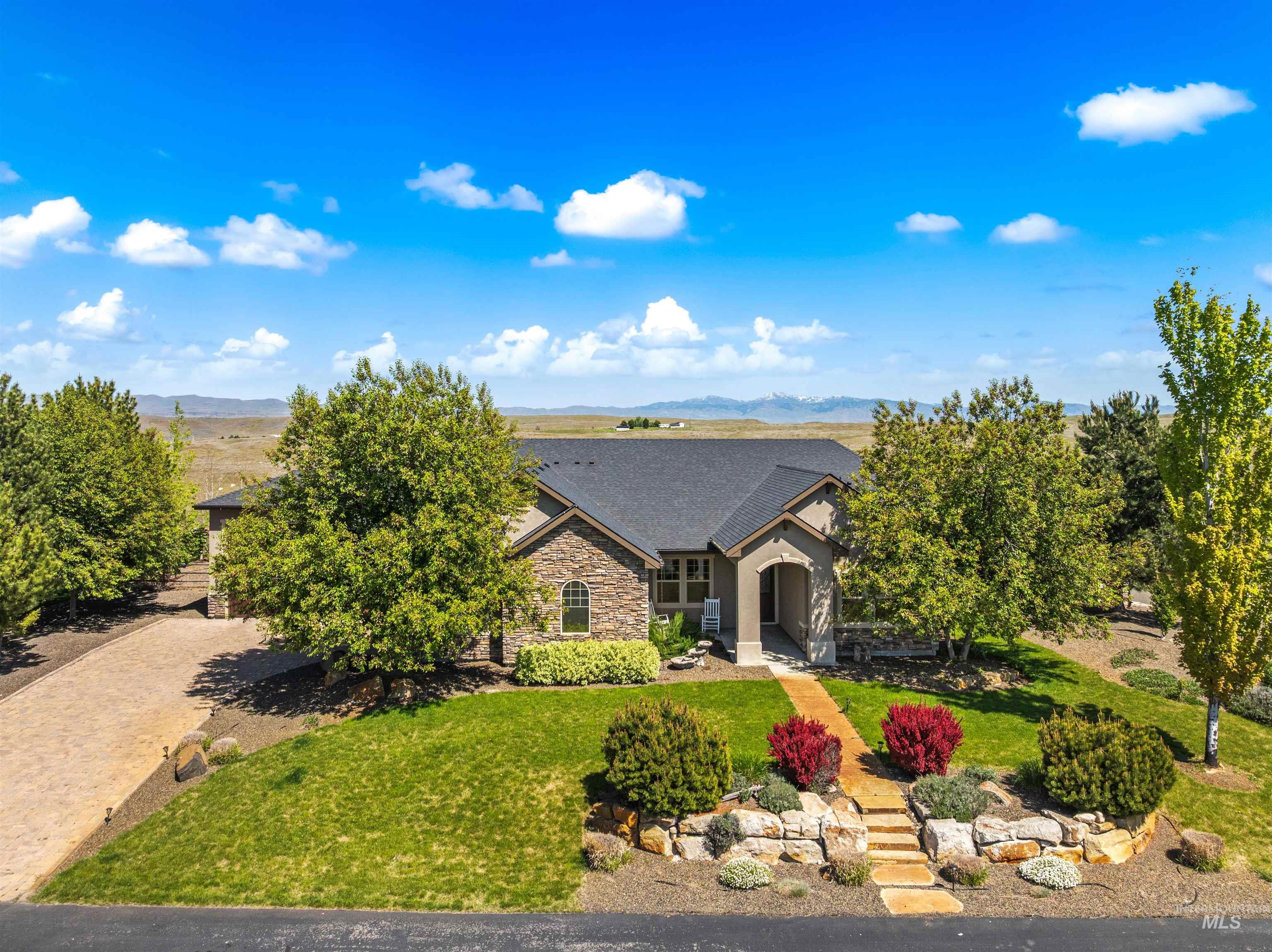 7521 North Grand Ridge Lane Eagle, ID 83616 - Photo 1 of 50 Contemporary single-story residence with a dark shingled roof, a paved driveway, and an attached two-car garage