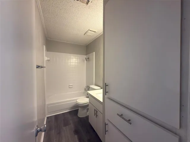 a bathroom with a granite countertop toilet a sink and a bathtub