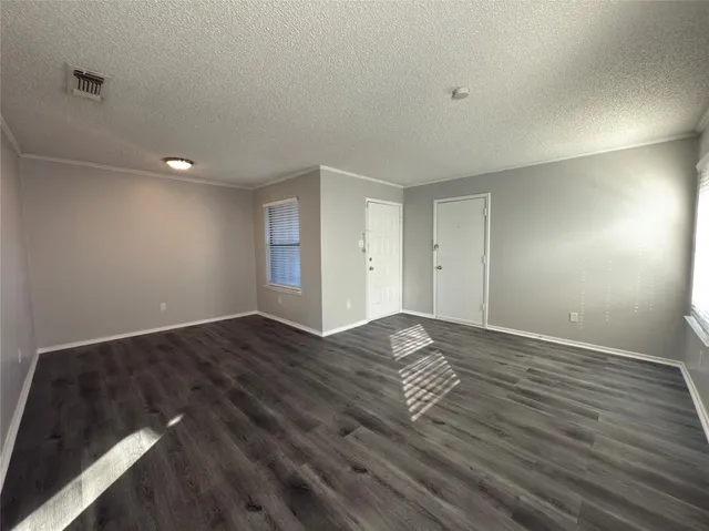 a view of empty room with wooden floor