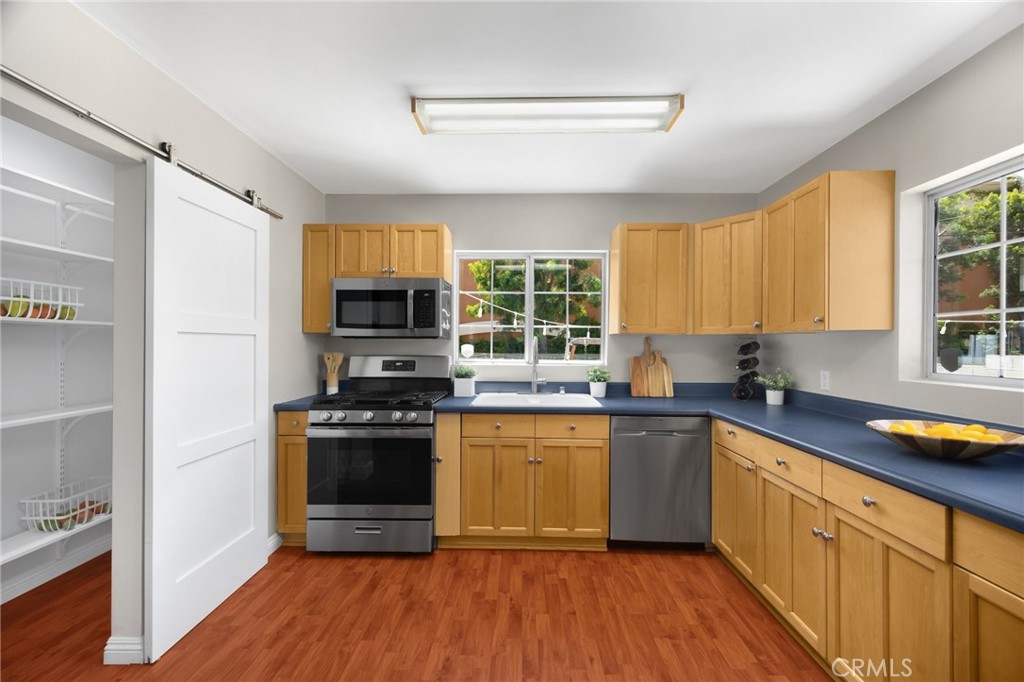 836 Willow Drive Brea, CA 92821 - Photo 9 of 35 a kitchen with stainless steel appliances granite countertop wooden cabinets a refrigerator a sink a stove a microwave and wooden floors