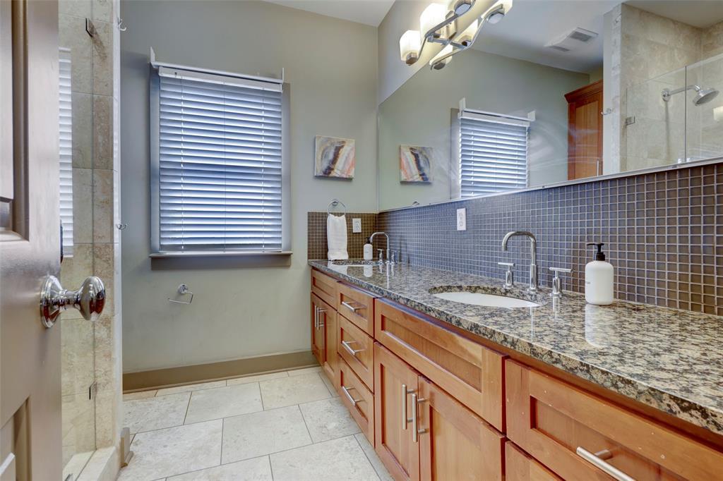 602 West N Loop Boulevard, Unit B Austin, TX 78751 - Photo 13 of 21 Polished stone tile floors pair with granite countertops in this dual-sink vanity setup.