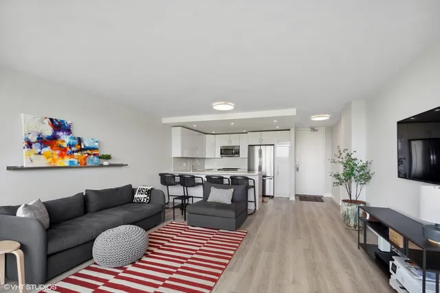 a living room with furniture a flat screen tv and a rug