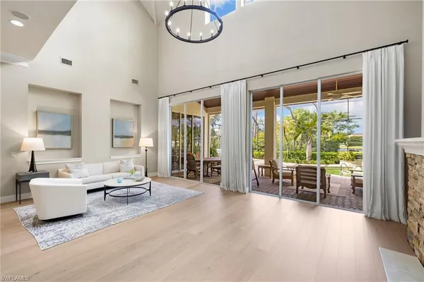 a living room with patio furniture and garden view