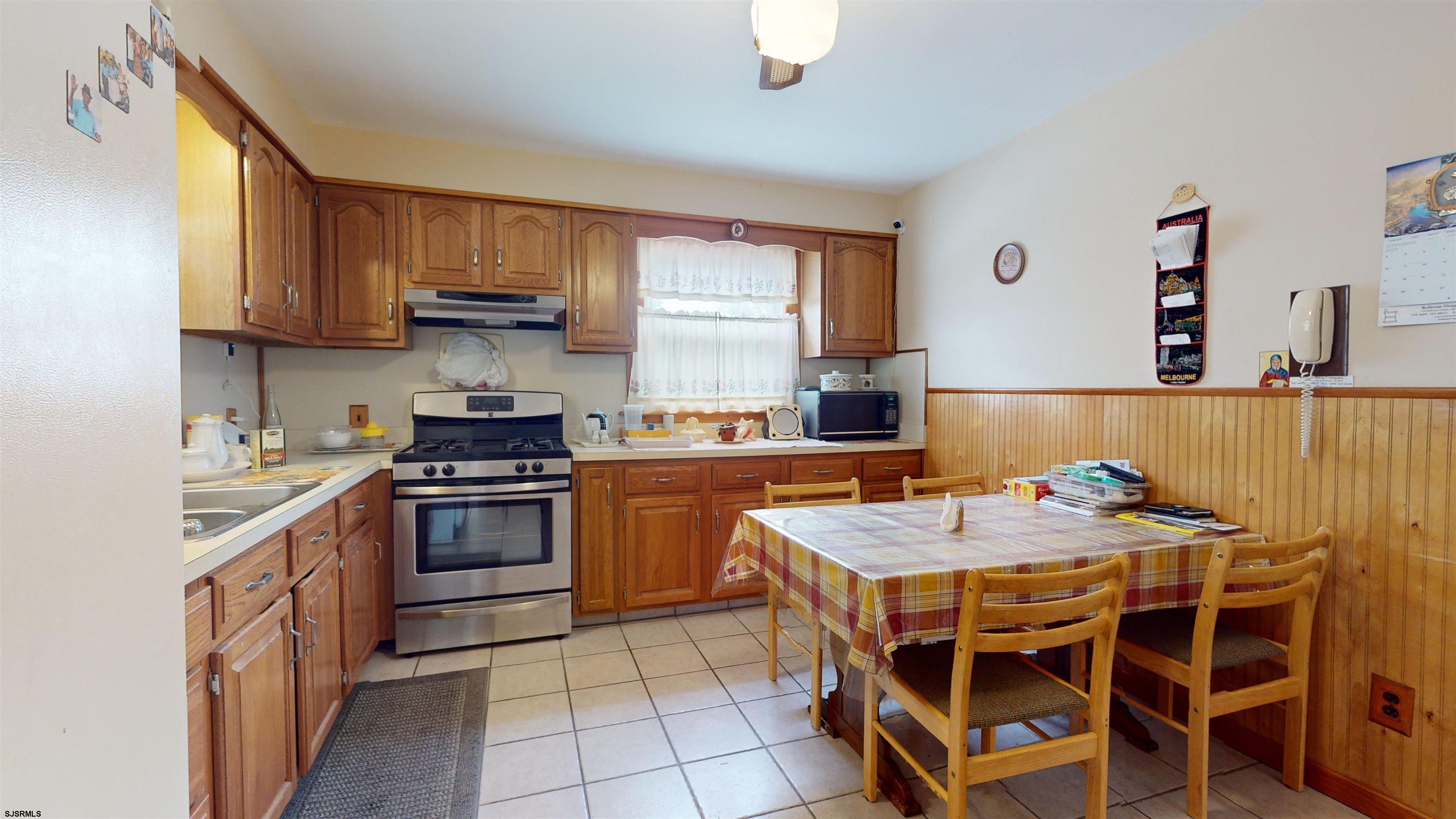 424 Pratt Street Hammonton, NJ 08037 - Photo 13 of 41 a kitchen with stainless steel appliances granite countertop a stove a sink dishwasher and a refrigerator with wooden cabinets