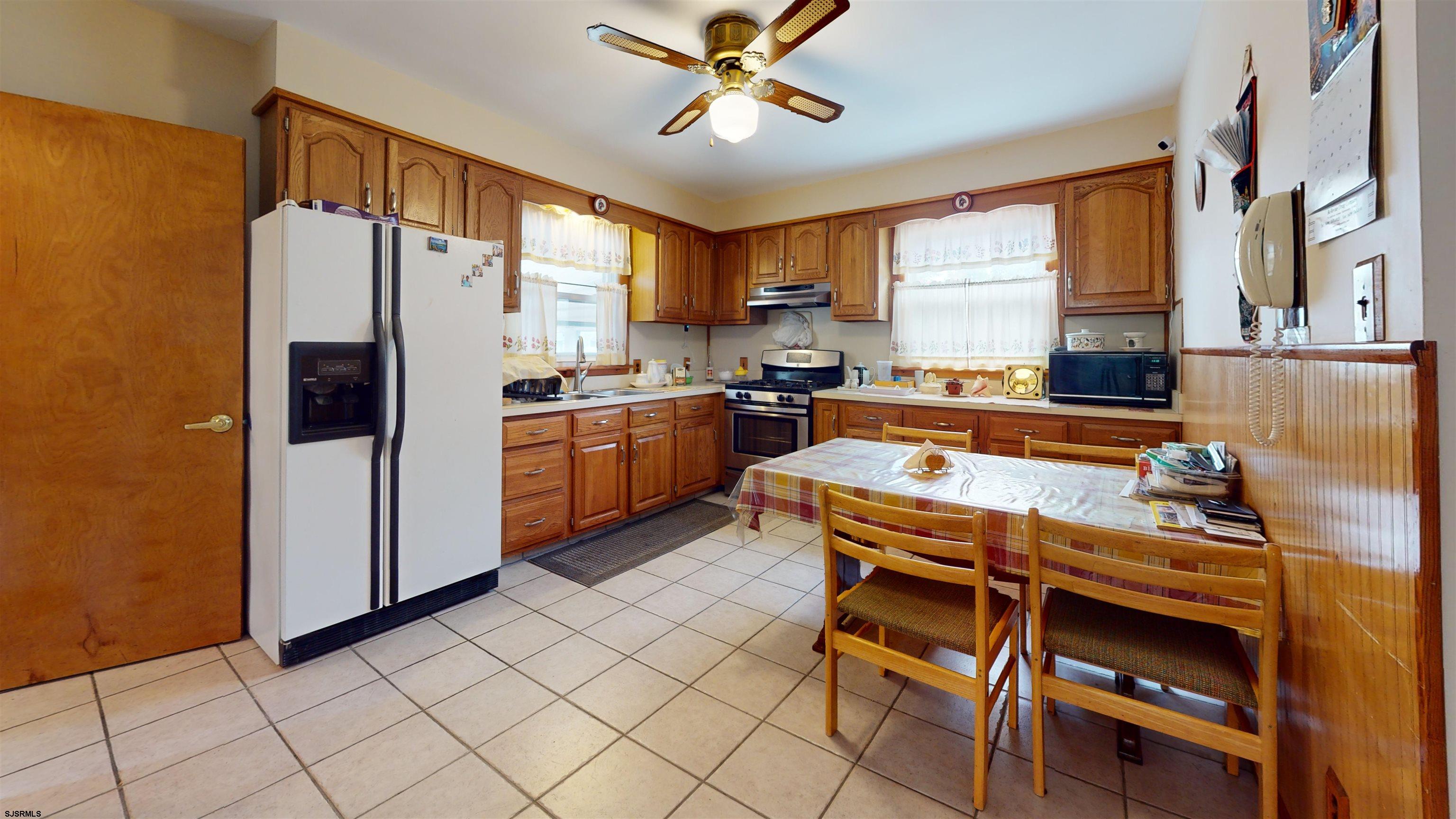 424 Pratt Street Hammonton, NJ 08037 - Photo 15 of 41 a kitchen with stainless steel appliances granite countertop a stove a refrigerator a sink a dining table and chairs with wooden floor