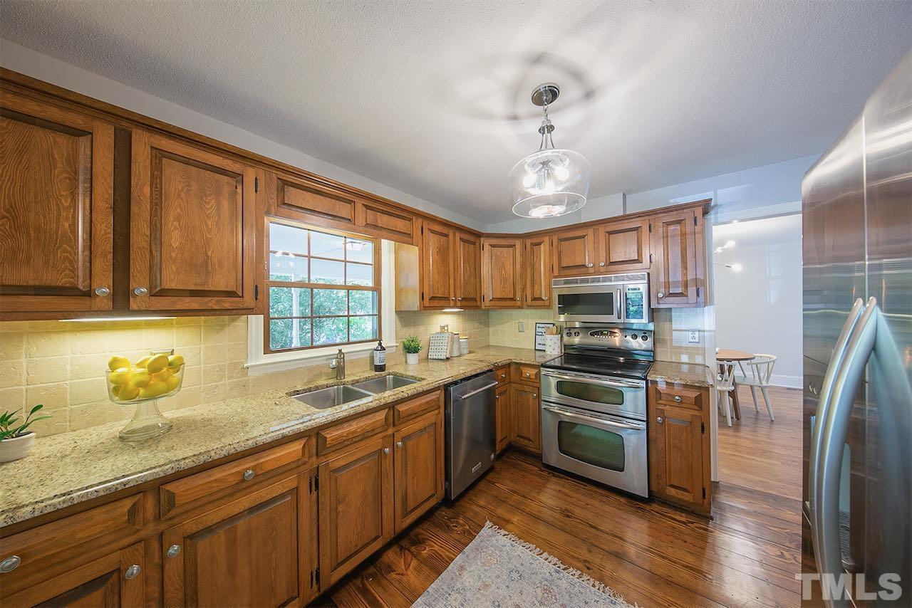 6420 Brandywine Road Raleigh, NC 27607 - Photo 6 of 28 a kitchen with stainless steel appliances granite countertop a sink stove and refrigerator