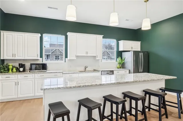 a kitchen with granite countertop white cabinets and stainless steel appliances