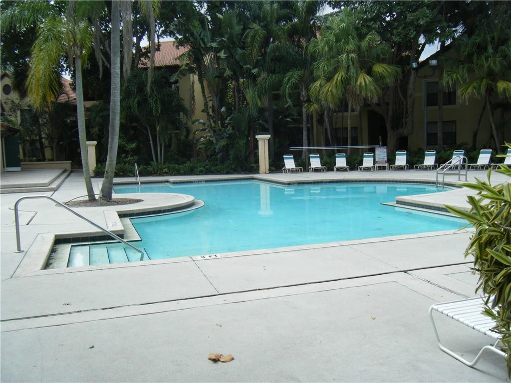 4421 West McNab Road, Unit 19 Pompano Beach, FL 33069 - Photo 17 of 20 a view of a swimming pool with a bench and trees