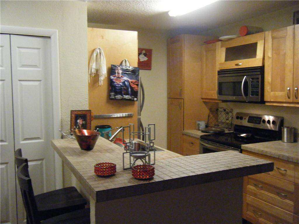 4421 West McNab Road, Unit 19 Pompano Beach, FL 33069 - Photo 2 of 20 a kitchen with a sink a microwave and cabinets