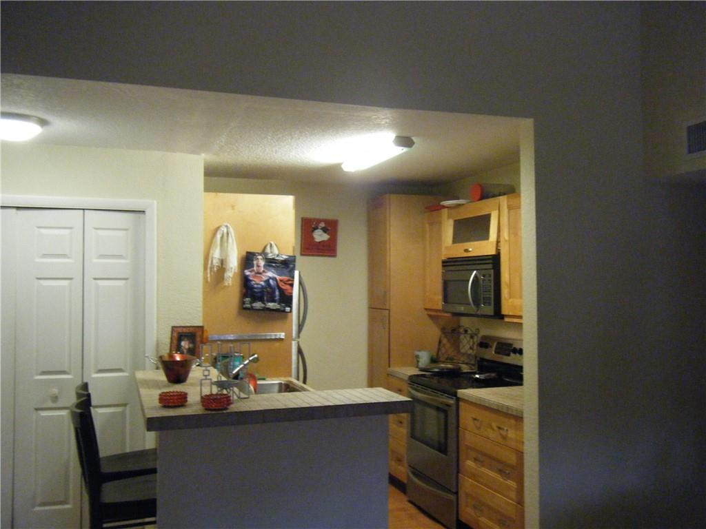 4421 West McNab Road, Unit 19 Pompano Beach, FL 33069 - Photo 8 of 20 a room with a wooden floor and gym equipment
