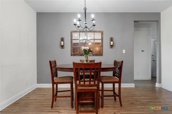 a view of a dining room with furniture wooden floor and a chandelier