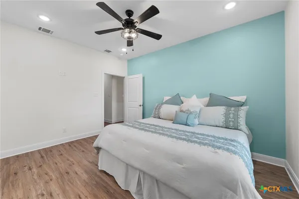 a bedroom with a large bed and a chandelier