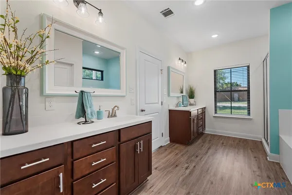 a room with a sink window and wooden floor