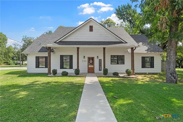 a front view of a house with a garden and yard