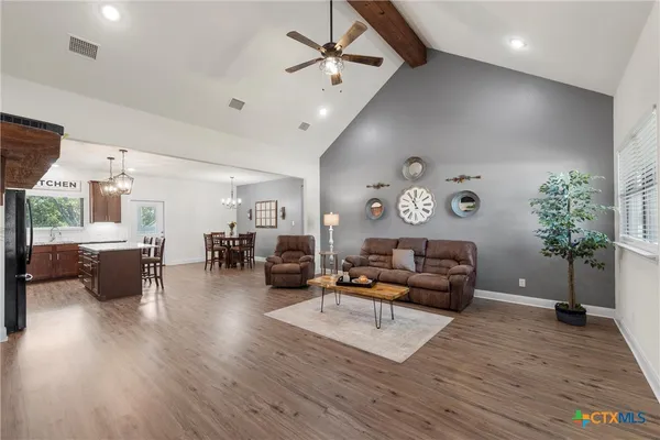 a living room with furniture and a wooden floor