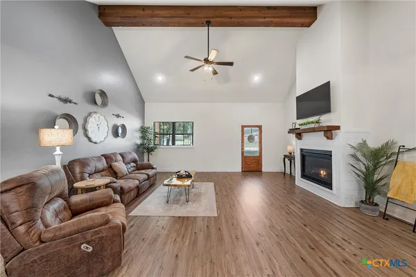 a living room with furniture a fireplace and a flat screen tv