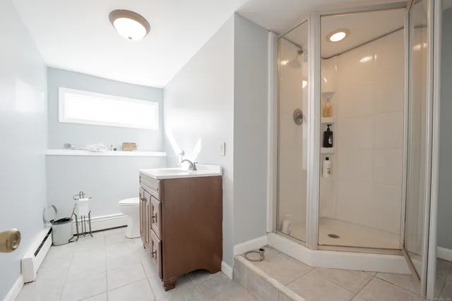 a bathroom with a sink a toilet and shower