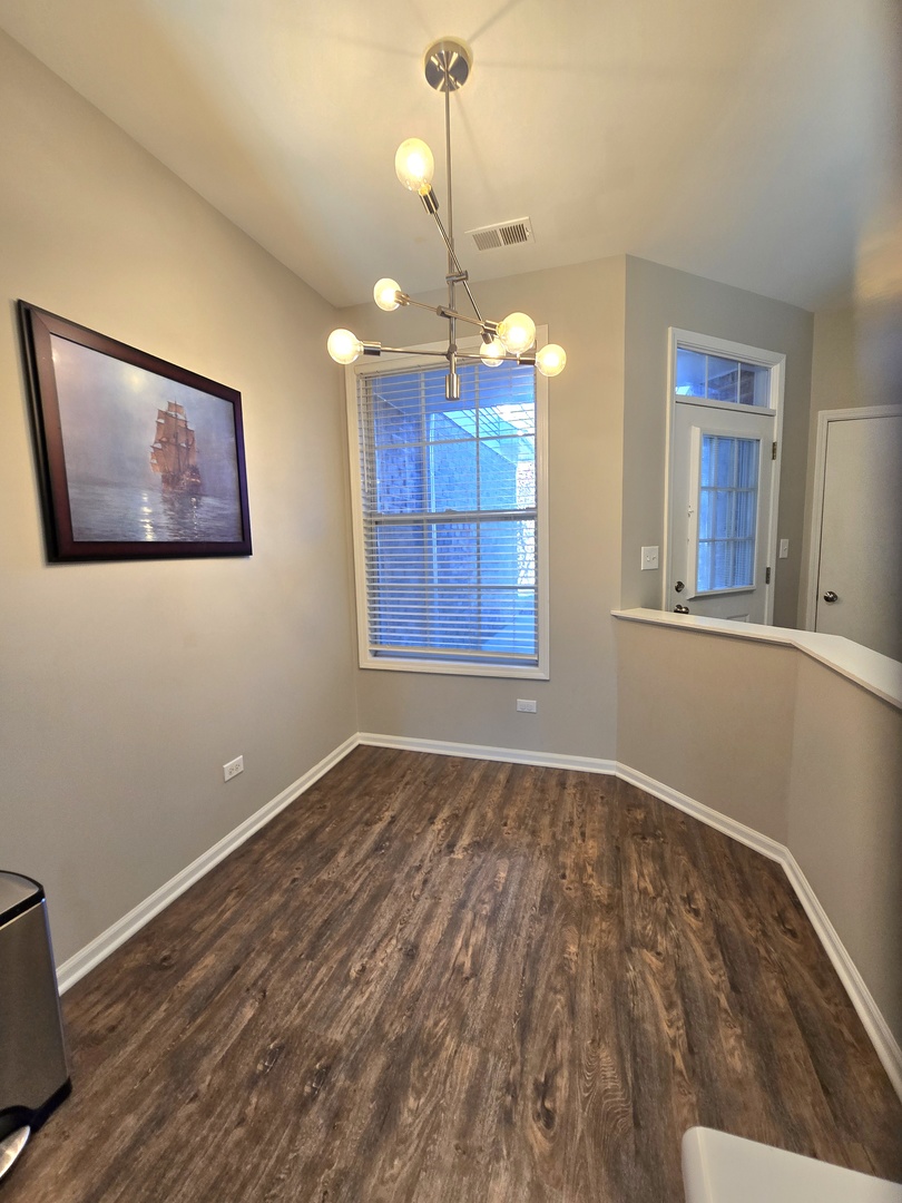 273 West 20th Street Lombard, IL 60148 - Photo 7 of 32 a view of an empty room with window and wooden floor
