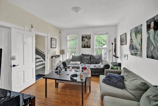 a living room with furniture fireplace and wooden floor