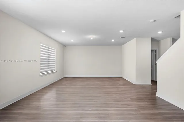 a view of a room with wooden floor and window