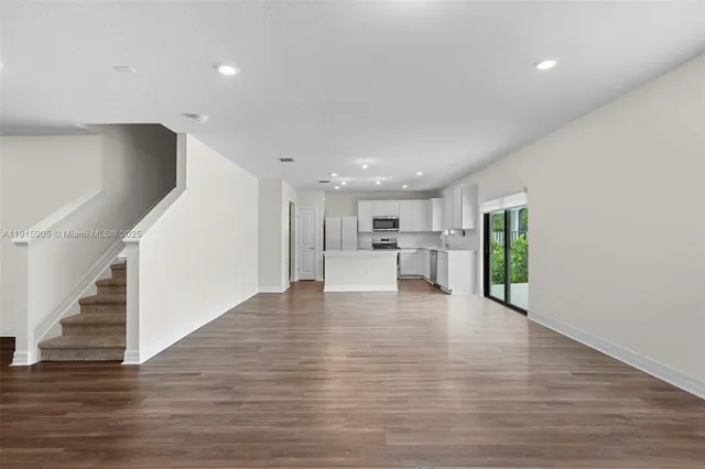 a view of kitchen with wooden floor and electronic appliances
