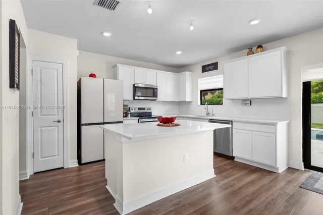 a kitchen with refrigerator cabinets and wooden floor