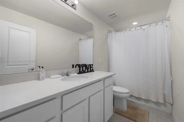 a bathroom with a sink toilet vanity and shower
