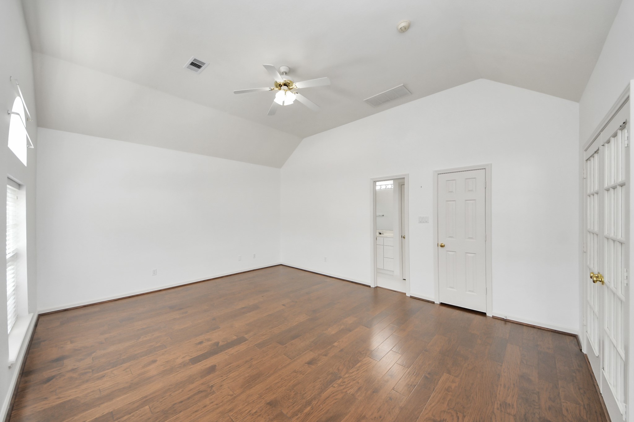 5815 Pheasant Ridge Lane Houston, TX 77041 - Photo 16 of 46 Spacious room with vaulted ceilings, elegant hardwood floors, and abundant natural light, featuring double French doors and convenient bathroom access.