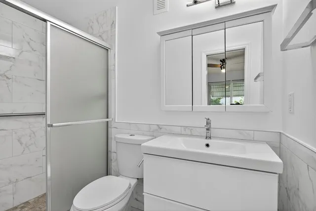 a bathroom with a sink a toilet and mirror