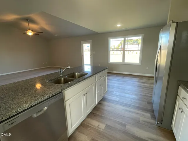 a large kitchen with a sink and dishwasher large oven a wooden floor