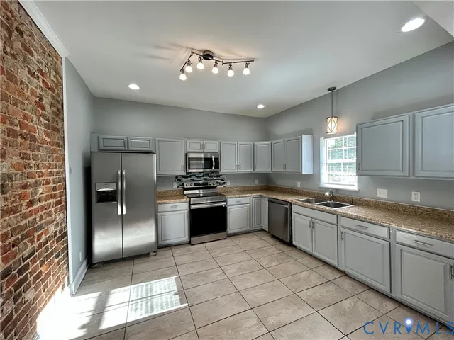 a kitchen with stainless steel appliances granite countertop a refrigerator and a sink