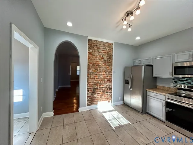 a view of an empty room with closet and a window