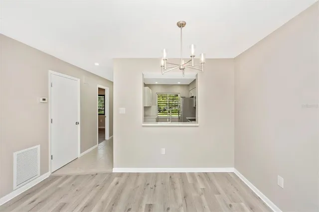 a view of empty room with wooden floor and window