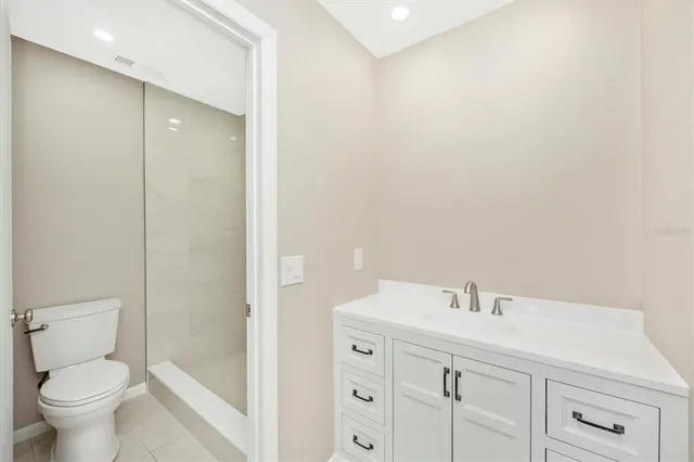 a white toilet sitting next to a shower