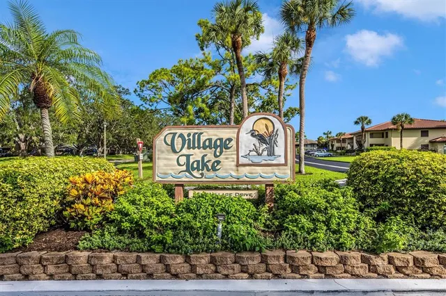 a view of a street sign under a large tree