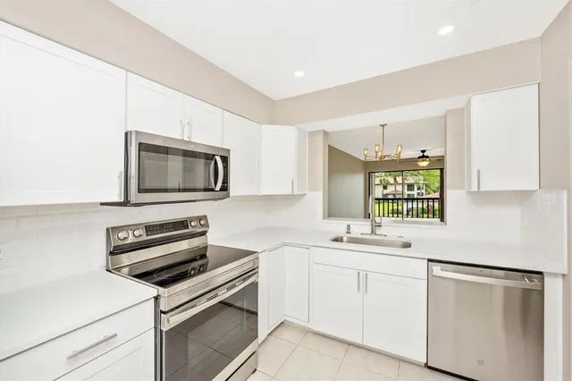 a kitchen with appliances a sink and cabinets