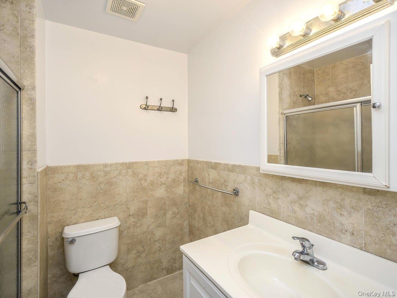 34 Firwood Road, Unit B Port Washington, NY 11050 - Photo 17 of 25 a bathroom with a sink a toilet and a mirror