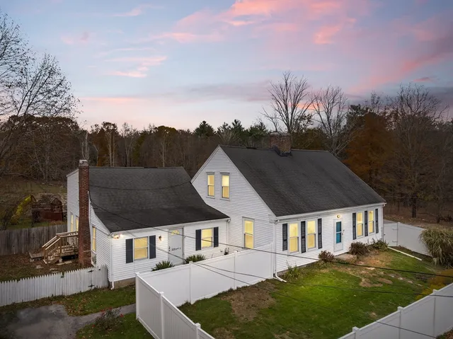 a front view of a house with a yard and mountain view in back
