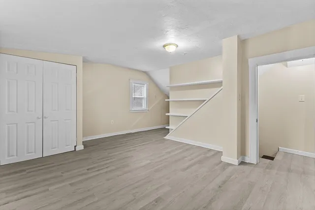 an empty room with wooden floor & entryway