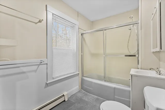 a bathroom with a shower a toilet and a sink