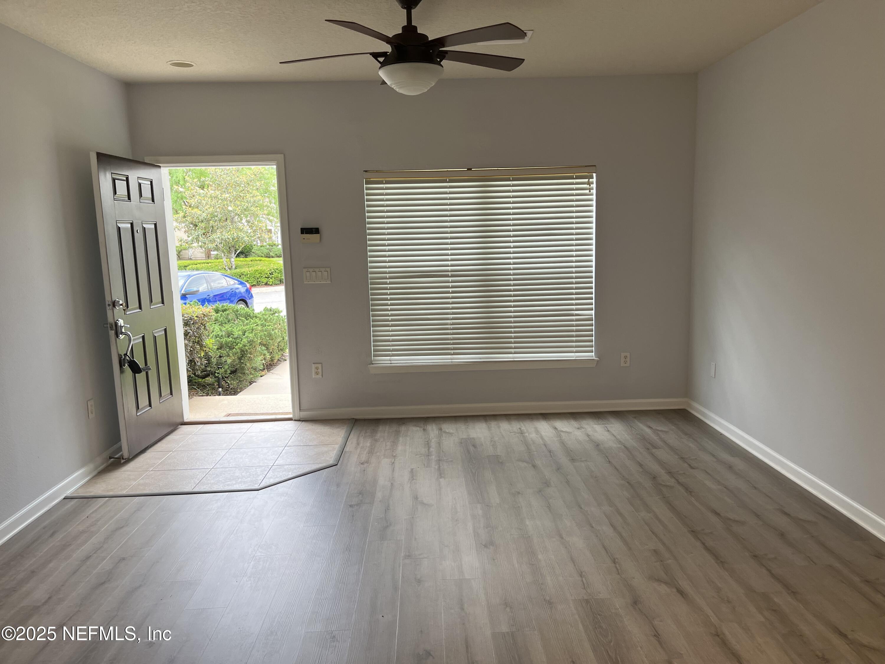 6747 Arching Branch Circle Jacksonville, FL 32258 - Photo 4 of 25 a view of an empty room with a window and wooden floor