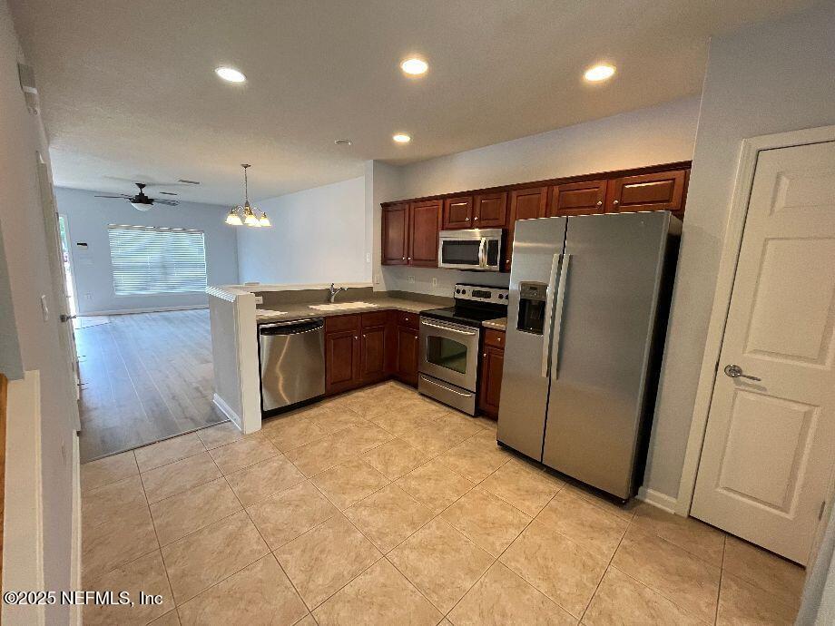 6747 Arching Branch Circle Jacksonville, FL 32258 - Photo 5 of 25 a kitchen with stainless steel appliances a refrigerator and a sink