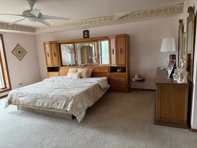 a spacious bedroom with a bed a dresser and a window