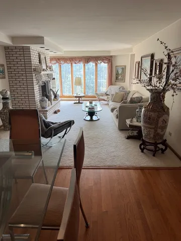 a living room with furniture floor to ceiling window and a flat screen tv
