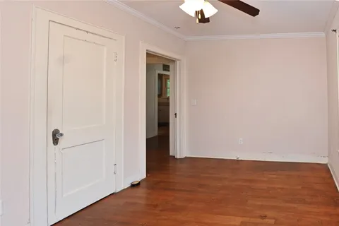 an empty room with wooden floor closet and windows