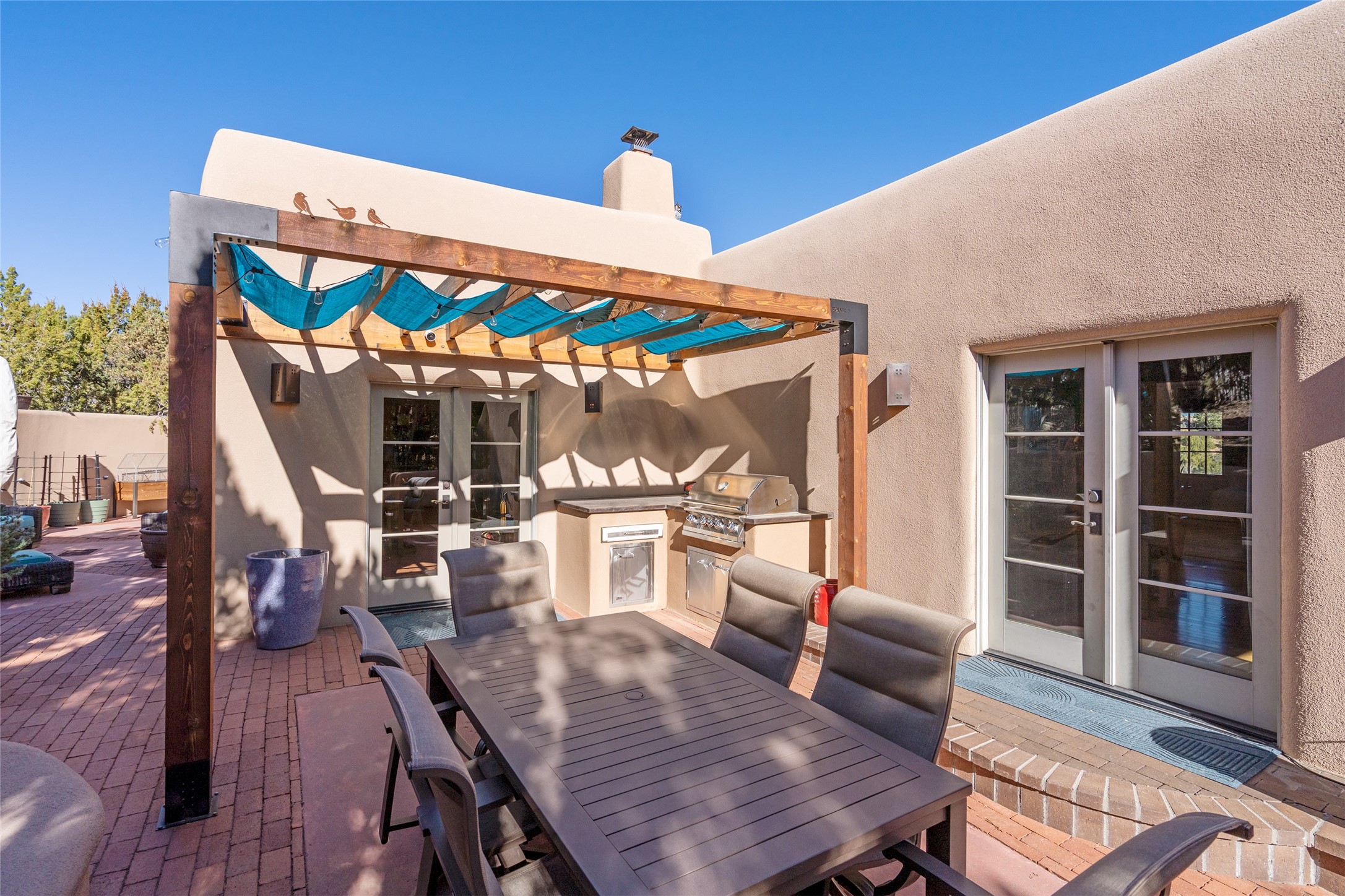 1204 Bandolina Road Santa Fe, NM 87501 - Photo 28 of 69 Back patio and view to side patio; French doors to right go to primary suite, French doors straight ahead to kitchen