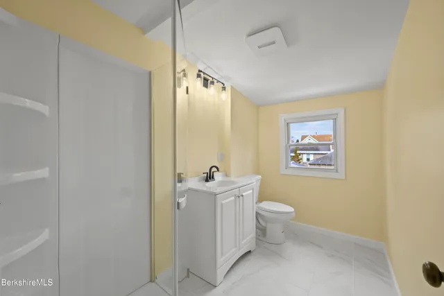 a bathroom with a sink mirror vanity and toilet