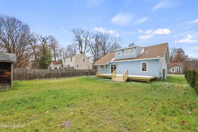 a view of a yard with a house and a large tree
