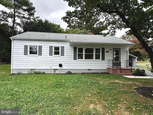 a white house that has a tree in front of a white house