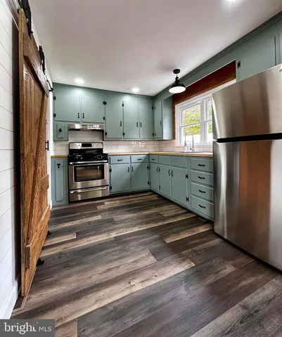 a kitchen with refrigerator cabinets and wooden floor